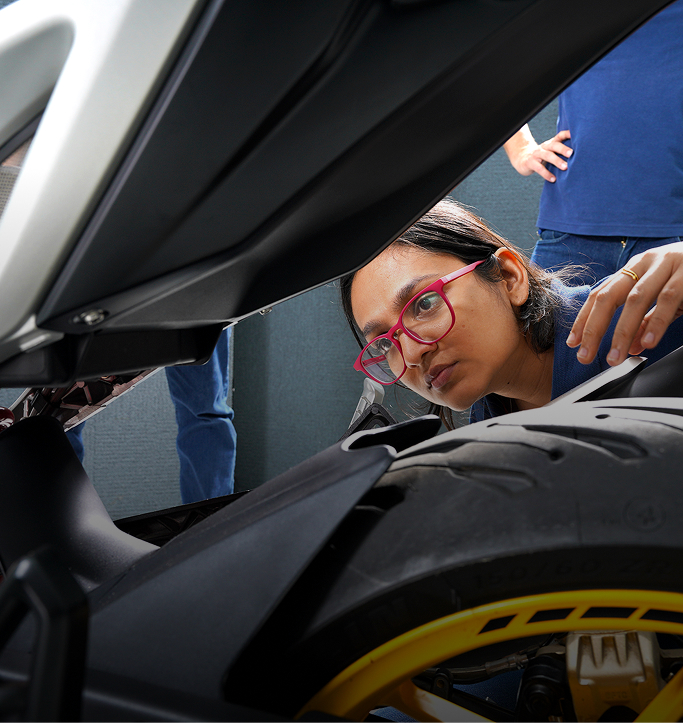 TVS engineer inspecting a motorcycle